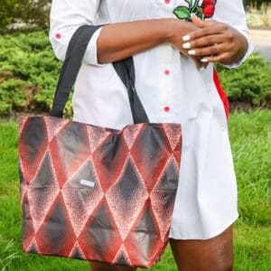 A woman holding onto a red and black bag