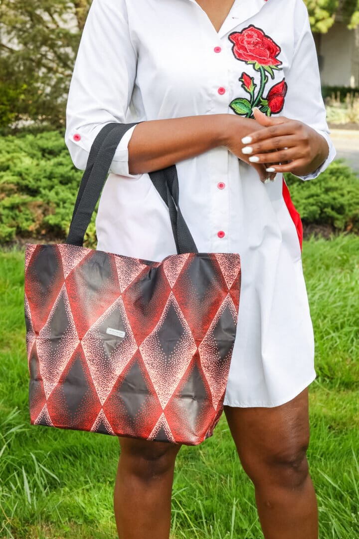 A woman holding onto a red and black bag