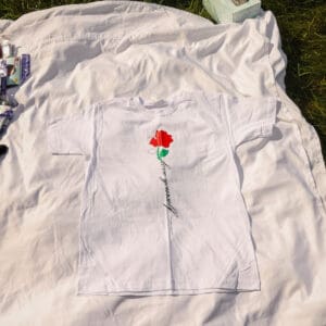 A white t-shirt with a red rose on it.